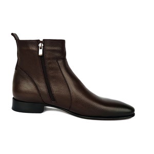 May include: Brown leather ankle boots with a zipper on the side.