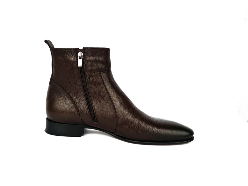 May include: Brown leather ankle boots with a zipper on the side.