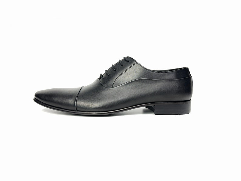May include: Black leather lace-up dress shoes with a pointed toe.