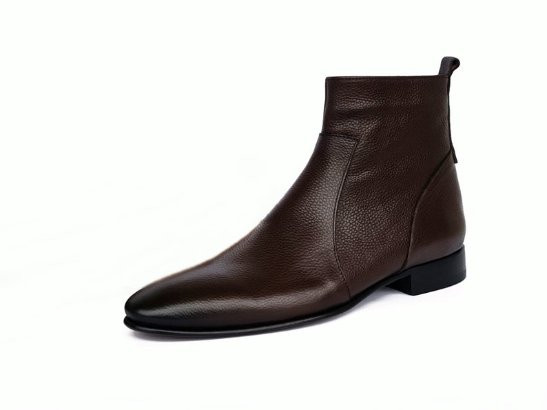 May include: A brown leather ankle boot with a pointed toe and a zipper on the side.