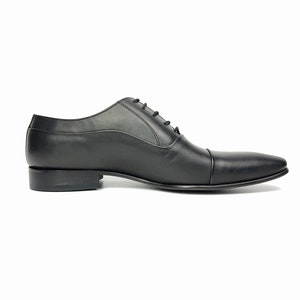 May include: A pair of black leather lace-up dress shoes with a pointed toe.