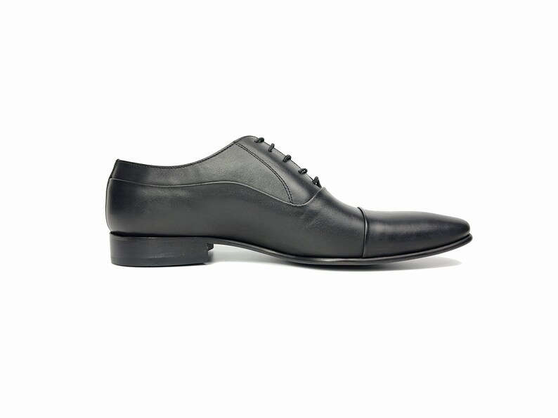 May include: A pair of black leather lace-up dress shoes with a pointed toe.