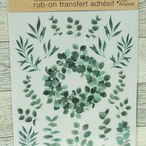May include: Sheet of rub-on transfers featuring green botanical designs, including a wreath and various leaf and branch arrangements. The package includes the text "Crafter's Square" and "rub-on transfers".