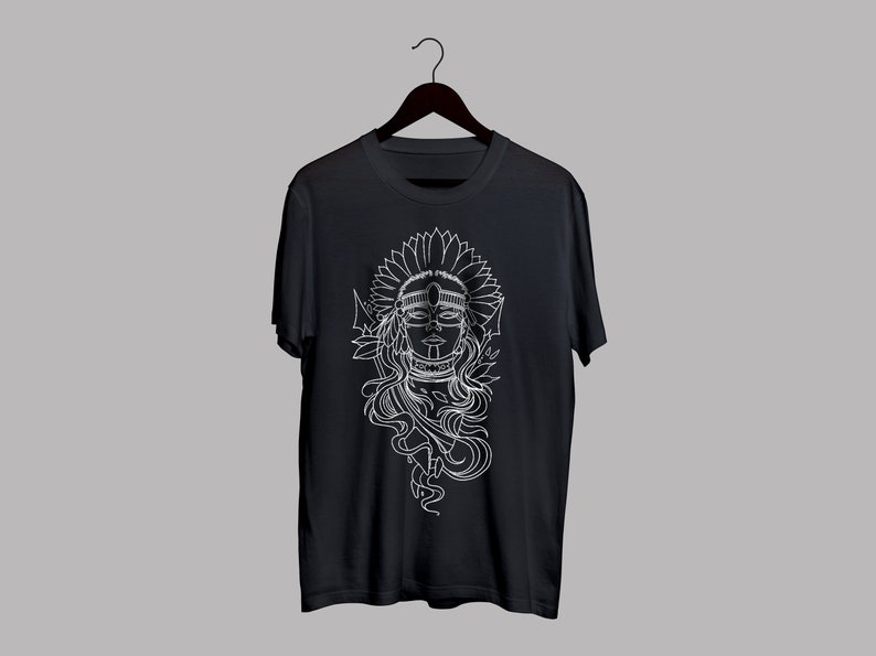 May include: Black t-shirt featuring a white graphic of a woman with a headdress and floral elements. The design is a detailed line drawing, creating a striking contrast against the dark fabric. The shirt is displayed on a hanger.