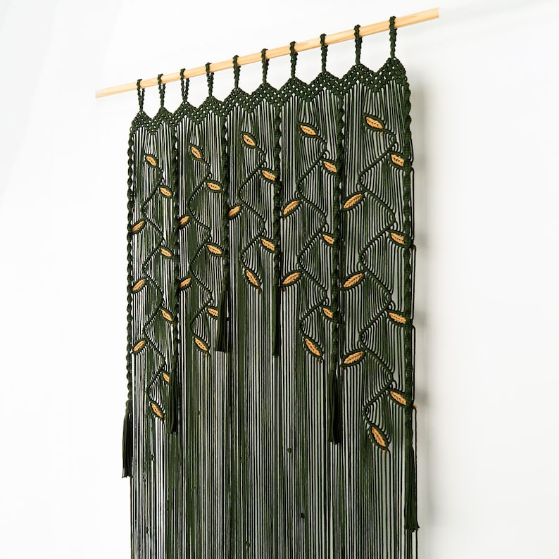 High-quality dark green macrame curtain displaying artisan knot-work and leaf motifs.