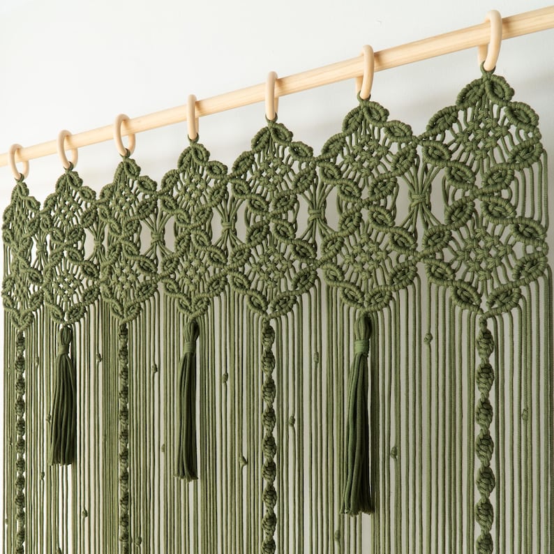 Hand-knotted moss green room divider with a complex diamond and floral pattern at the top.