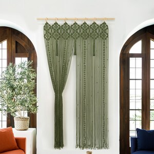 Floor-to-ceiling olive green macrame curtain used as a bohemian closet cover.