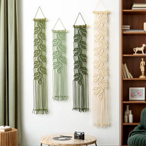 Tapiz de macramé botánico para pared, pilares de arte en fibra botánica en tonos verde y crema.
