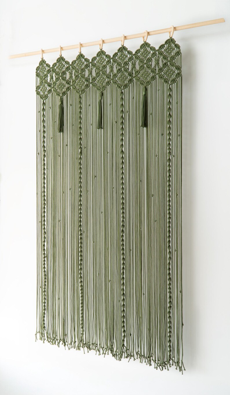 Symmetrical long macrame hanging in a trendy forest-inspired olive green colorway.