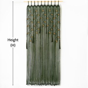 Dark green macrame wall tapestry and doorway divider creating a bold biophilic statement backdrop in a bright home interior