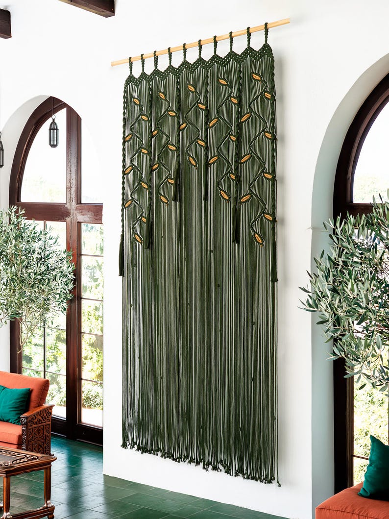 Decorative dark green fiber art tapestry with a symmetrical botanical vine layout.