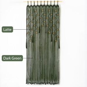 Bohemian dark green macrame door curtain with sweeping floor-length fringe suspended on a slim wooden dowel