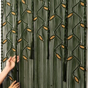 Long-form forest green macrame curtain with contrast-color latte leaf highlights.
