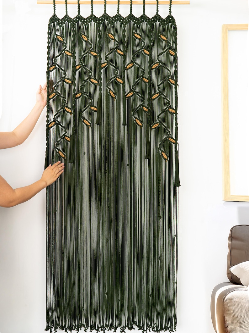 Hand-woven dark green macrame hanging with delicate almond-shaped latte accents.
