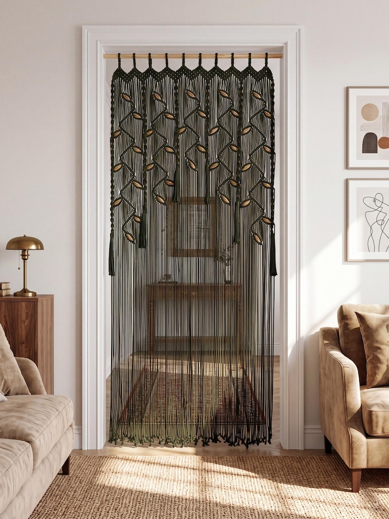 Dark green macrame doorway curtain featuring tan hand-knotted leaf accents and tassels hanging in a white door frame.