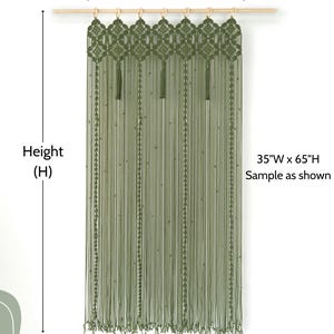 High-quality mossy green fiber art displaying a symmetrical floral weave and long fringe.