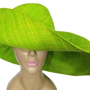 May include: A bright lime green sun hat with a wide brim. The hat is made from a woven material, giving it a textured appearance. The brim is generously sized and curved. The hat is displayed on a mannequin head.