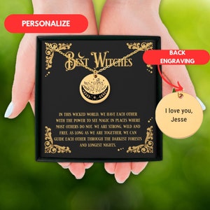 Peut inclure: Une boîte cadeau noire contenant un collier en or. Le collier présente un pendentif en forme de croissant de lune avec des cristaux et des étoiles. La boîte a un fond noir avec des lettres dorées qui disent "Best Witches". Le dos de la boîte a un cercle doré avec le texte "Je t'aime, Jesse".