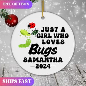 May include: White ceramic ornament with a green, red, and black bug illustration. The text reads "Just a girl who loves bugs Samantha - 2024".