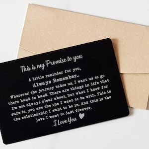 May include: Black metal card with a silver inscription that reads "This is my Promise to you. A little reminder for you, Always Remember... Wherever the journey takes us, I want us to go there hand in hand. There are things in life that I'm not always clear about, but what I know for sure is, you are the one I want to be with. This is the relationship I want to be in. And this is the love I want to last forever. I Love You".