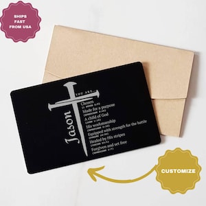 May include: A black metal card with a silver cross design and the name "Jason". The card includes inspirational text from the Bible. An envelope is behind the card. The words "Customize" and "Ships Fast From USA" are also visible.