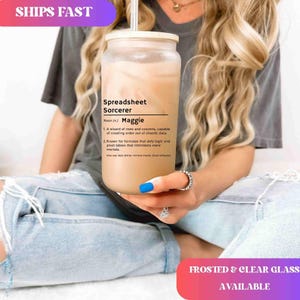 May include: A frosted glass tumbler with a bamboo lid and straw, filled with a light brown beverage. The tumbler features the text "Spreadsheet Sorcerer" with a definition and the name "Maggie". The image also includes the text "Frosted & Clear Glass Available".
