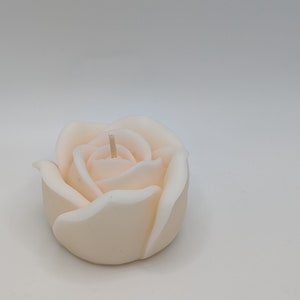 May include: A white rose-shaped candle with a single wick.