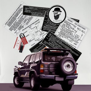 May include: A black Nissan Pathfinder SUV with a spare tyre mounted on the back. The vehicle has a sticker on the rear window that says "R12" and "Air Conditioner". There are several other stickers on the vehicle, including one with a skull and crossbones.