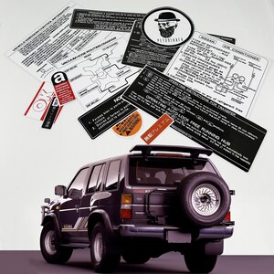 May include: A black Nissan Pathfinder SUV with a spare tyre mounted on the back. The vehicle has a sticker on the rear window that reads "Free Running Hub".