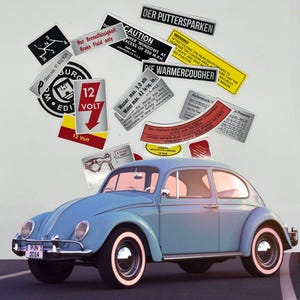 May include: A light blue vintage Volkswagen Beetle with white-walled tires and various stickers. The stickers include warnings, specifications, and the text "12 Volt". The car has a license plate that reads "P-JN 2014".