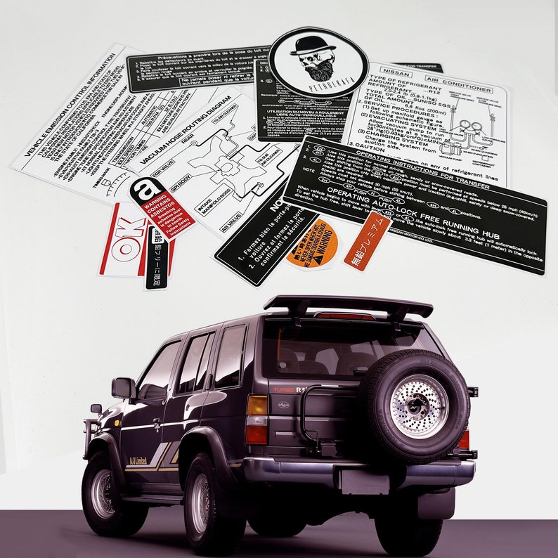 May include: A black Nissan Pathfinder SUV with a spare tyre mounted on the back. The vehicle has a sticker on the rear window that says "Auto-Lock Free Running Hub".