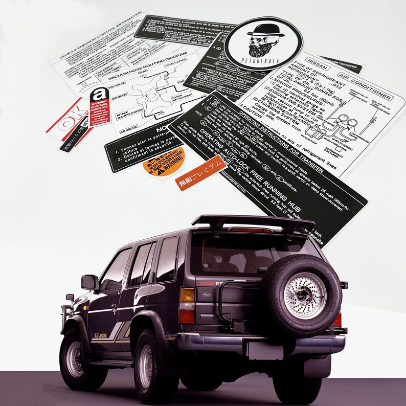 May include: A black Nissan Pathfinder SUV with a spare tyre mounted on the back. The vehicle has a roof rack and a sticker on the back that says "Free Running Hub".