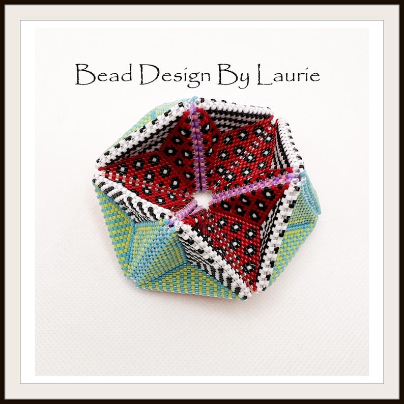 Puede incluir: Una forma geom&eacute;trica de cuentas multicolores con una abertura en forma de estrella en el centro. La forma est&aacute; hecha de cuentas rojas, blancas, negras, verdes y azules. El texto "Bead Design By Laurie" es visible en la parte superior de la imagen.