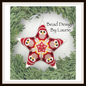May include: A beaded star ornament with a festive owl design. The star is red, white, and black, with yellow accents. The text "Bead Design By Laurie" is visible. The ornament is suspended against a backdrop of green foliage.