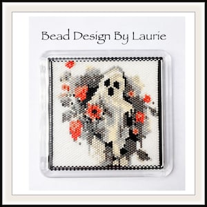 Puede incluir: Un fantasma de cuentas con un cuerpo blanco y ojos negros se encuentra frente a un fondo de flores rojas y negras. El trabajo de cuentas está enmarcado en un marco de plástico transparente. El texto "Bead Design By Laurie" está impreso en la parte superior de la imagen.