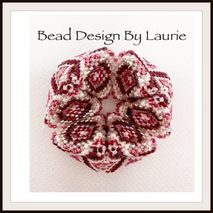 May include: A close-up of a beaded flower in shades of white and burgundy. The flower is made with small, intricate beads and has a geometric design. The text "Bead Design By Laurie" is visible at the top of the image.