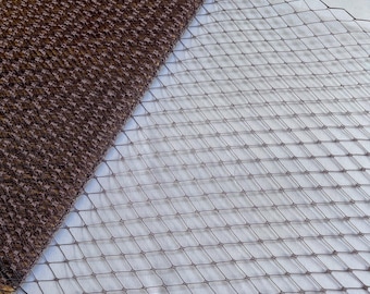 May include: A diagonal composition featuring two distinct textiles. One is a textured, brown fabric with a woven pattern. The other is a brown, diamond-patterned netting. The contrasting textures and patterns create visual interest.