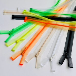 Puede incluir: Surtido de cintas de cremallera de colores en varios colores, incluyendo negro, blanco, naranja, amarillo y verde. Las cremalleras están hechas de un material de malla y tienen una variedad de longitudes.