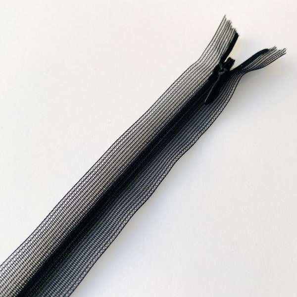 Cremallera invisible y oculta de peso pluma en color negro: 66 cm de largo. Cremallera superligera con cinta transparente para vestidos, batas y faldas.