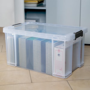 May include: A clear plastic storage bin with a lid, filled with several hanging file folders. The bin is sitting on a tiled floor.