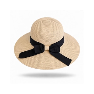May include: A beige straw hat with a rounded crown and a wide brim. The hat features a black fabric ribbon band wrapped around the base of the crown, tied into a bow at the front with two long, flat ends hanging down over the brim surface.