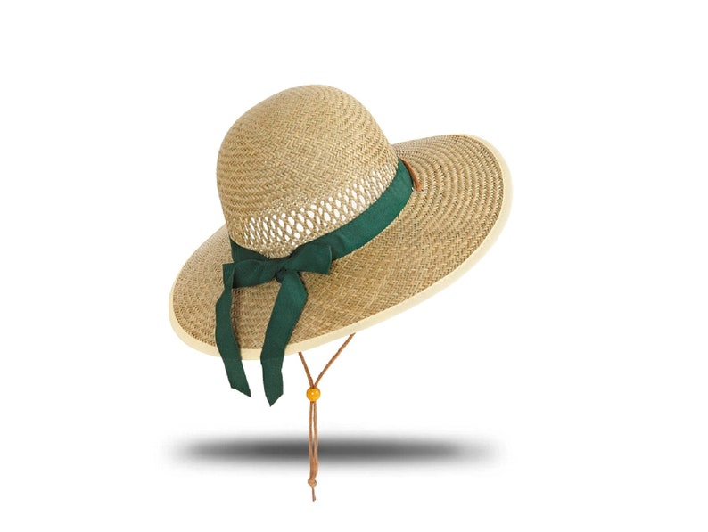 May include: A wide-brimmed straw hat with a green ribbon and a brown cord.