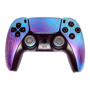 May include: A black and blue video game controller with a topographic pattern in shades of blue, purple, and pink. The controller has black buttons and joysticks, with the PlayStation logo in the center.