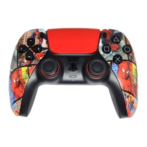 Könnte beinhalten: Schwarzer und roter PlayStation 5-Controller mit einem Spider-Man-Comic-Design. Der Controller hat ein rotes Touchpad, schwarze Tasten und eine Spider-Man-Grafik an den Seiten. Er hat ein PlayStation-Logo.