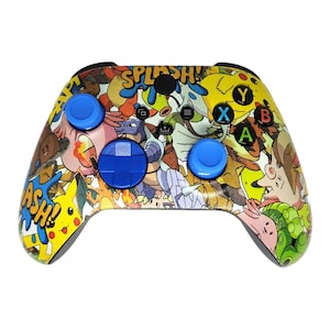 May include: A patterned video game controller with a cartoon design and the words "SPLASH!" and "ASH!". The controller has blue buttons and a directional pad. The standard X, Y, A, and B buttons are visible.