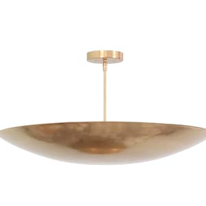 a large brass bowl hanging from a ceiling fixture