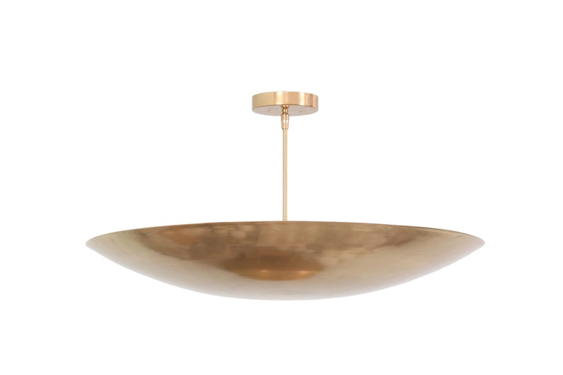 a large brass bowl hanging from a ceiling fixture