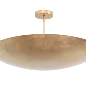 a large brass bowl hanging from a ceiling fixture