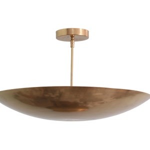 a large brass bowl hanging from a ceiling fixture
