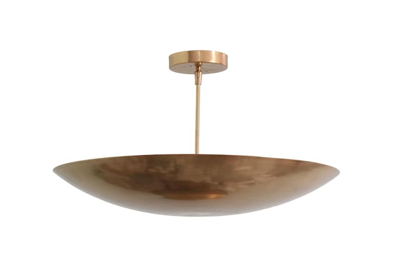 a large brass bowl hanging from a ceiling fixture